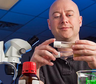 托德·布兰肯希普教授 examines test tube samples in a research lab.